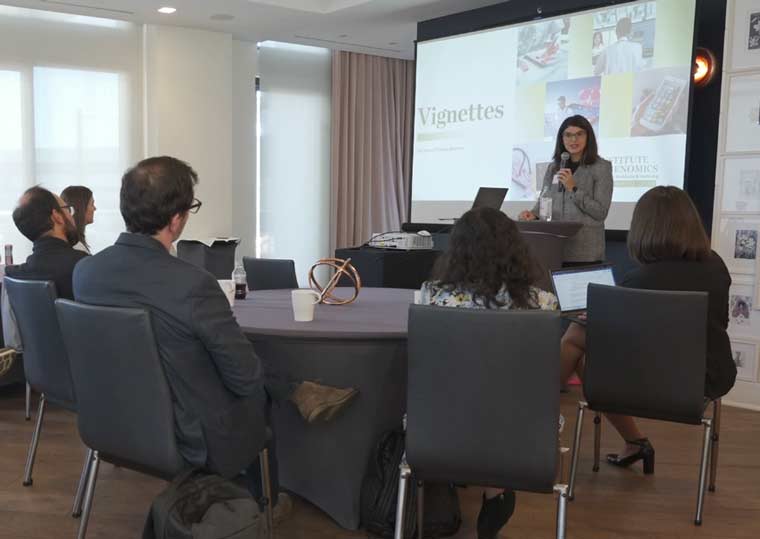 Picture of facilitator speaking to group of people in front of presentation screen.