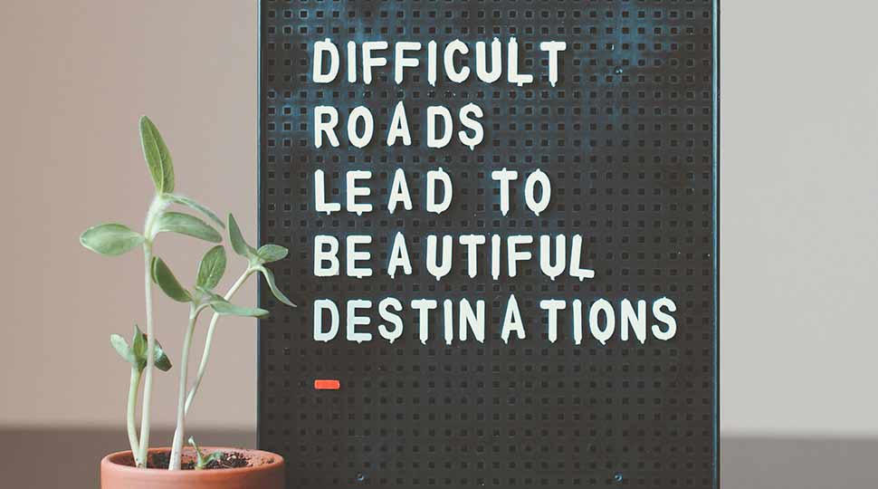 Difficult roads lead to beautiful destinations desk decor with small plant